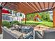 Covered patio with comfortable seating area, overlooking the backyard with a swing set and play area at 4303 Thetford Rd, Durham, NC 27707