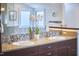 Bathroom featuring double sinks with granite counters, decorative mirrors, and mosaic tile backsplash and trim at 4303 Thetford Rd, Durham, NC 27707
