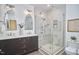Bright bathroom featuring double sink vanity, decorative mirrors, and glass-enclosed shower with tile surround at 4303 Thetford Rd, Durham, NC 27707