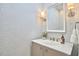 Elegant powder room with stylish wallpaper, decorative mirror, and modern vanity with sleek fixtures at 4303 Thetford Rd, Durham, NC 27707