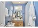 Charming blue bathroom features a wood vanity, mirror, and white shower curtain at 4303 Thetford Rd, Durham, NC 27707
