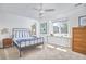 Neutral bedroom with natural light, ceiling fan, and modern furnishings including bedside tables and dresser at 4303 Thetford Rd, Durham, NC 27707