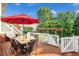 Outdoor deck with dining area, umbrella, pergola and a playset in the background for Gathering fun at 4303 Thetford Rd, Durham, NC 27707