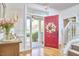 Bright, open foyer with hardwood floors, a welcoming red door, and a glimpse of the front yard at 4303 Thetford Rd, Durham, NC 27707