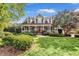 Inviting front exterior showcases lush lawn and landscaping, columns, and a red front door at 4303 Thetford Rd, Durham, NC 27707