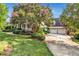 Charming home with a welcoming porch, mature landscaping, and a large tree with flowering pink blossoms at 4303 Thetford Rd, Durham, NC 27707