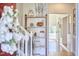 Hallway with hardwood floors showcases a decorative shelf and a glimpse of an outdoor porch at 4303 Thetford Rd, Durham, NC 27707