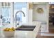 Bright kitchen island features a modern faucet, double sink, and white marble countertops at 4303 Thetford Rd, Durham, NC 27707
