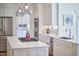 Modern kitchen boasts stainless steel appliances, white cabinetry, and a center island with a cooktop at 4303 Thetford Rd, Durham, NC 27707
