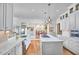 Spacious kitchen features hardwood floors, white cabinetry, stainless appliances, and an island cooktop at 4303 Thetford Rd, Durham, NC 27707