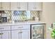 Bright kitchen features white cabinets, a beverage refrigerator, and decorative tile backsplash at 4303 Thetford Rd, Durham, NC 27707