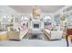 Inviting living room with neutral palette, fireplace, large windows, and an elegant chandelier at 4303 Thetford Rd, Durham, NC 27707