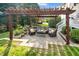 Beautiful backyard patio with cozy seating area, a pergola, and lush landscaping for outdoor entertaining at 4303 Thetford Rd, Durham, NC 27707