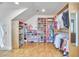 Spacious walk-in closet featuring custom shelving for clothing and shoes with natural lighting and wood floors at 4303 Thetford Rd, Durham, NC 27707