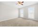 Inviting bedroom features carpet, a ceiling fan, and natural light from two large windows at 44 Loop Rd, Archer Lodge, NC 27527