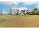 Exterior of the home with a spacious front lawn and mature trees, set against a blue sky backdrop at 44 Loop Rd, Archer Lodge, NC 27527