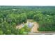 Aerial view of a home surrounded by lush, green trees at 468 Loftis Loop Rd, Roxboro, NC 27574