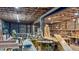 Wide view of a spacious basement area with walls and ceiling exposed, and with lots of equipment for wood working at 468 Loftis Loop Rd, Roxboro, NC 27574