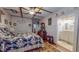 Charming bedroom with floral bedding, wood floors, and adjacent bathroom entrance at 468 Loftis Loop Rd, Roxboro, NC 27574