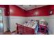 Cozy bedroom with red walls, white wainscoting, and a bed with patriotic themed bedding at 468 Loftis Loop Rd, Roxboro, NC 27574