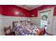 Quaint bedroom with red walls, wainscoting, and patriotic bedding, with a door to the outside at 468 Loftis Loop Rd, Roxboro, NC 27574