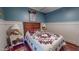 Comfortable bedroom showcasing wood floors, blue walls, paneled walls, and a patterned quilt at 468 Loftis Loop Rd, Roxboro, NC 27574