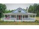 Alluring single-story home showcasing a cozy front porch and red door, complemented by an American flag at 468 Loftis Loop Rd, Roxboro, NC 27574
