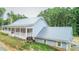 Side view showing metal roof and charming covered front porch, blending country charm with modern amenities at 468 Loftis Loop Rd, Roxboro, NC 27574