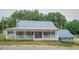 Charming single-story home featuring a welcoming front porch with a metal roof and a beautifully landscaped yard at 468 Loftis Loop Rd, Roxboro, NC 27574