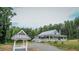 Single-story home nestled among mature trees, featuring a covered front porch and nearby wishing well at 468 Loftis Loop Rd, Roxboro, NC 27574