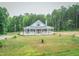 Serene view of home with open lawn and mature trees, featuring a covered porch at 468 Loftis Loop Rd, Roxboro, NC 27574