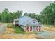 Home featuring an attached garage with red doors, a wraparound porch, and mature landscaping at 468 Loftis Loop Rd, Roxboro, NC 27574