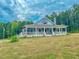 Charming home with a wraparound porch, white railings, and a serene backdrop of trees at 468 Loftis Loop Rd, Roxboro, NC 27574