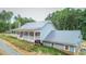 Charming home with a metal roof, a covered porch, and surrounded by beautiful trees at 468 Loftis Loop Rd, Roxboro, NC 27574