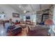 Living room featuring hardwood floors, a ceiling fan, a stone accent wall with a fireplace, and comfortable seating at 468 Loftis Loop Rd, Roxboro, NC 27574