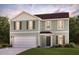 Charming two-story home featuring a welcoming entrance, attached garage, and beautifully landscaped front yard at 5005 Harrier Dr, Snow Camp, NC 27349