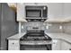 Stainless steel oven and microwave, granite countertops, and gray tile backsplash at 503 N Sellers St, Selma, NC 27576