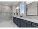 Bright bathroom features marble countertops, double sinks, a large window, and glass shower at 508 Moore Hill Way, Holly Springs, NC 27540