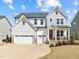 Charming two-story home featuring a gray and white color scheme, well-manicured lawn, and inviting front porch at 508 Moore Hill Way, Holly Springs, NC 27540