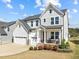 Charming two-story home featuring a gray and white color scheme, well-manicured lawn, and inviting front porch at 508 Moore Hill Way, Holly Springs, NC 27540