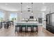 Open kitchen and eat-in area boasts an island with seating and stainless steel appliances at 508 Moore Hill Way, Holly Springs, NC 27540