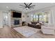Bright living room with a stone fireplace, large windows, and cozy seating area at 508 Moore Hill Way, Holly Springs, NC 27540