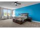 Large main bedroom boasts bright accent wall, ceiling fan, and plush furnishings at 508 Moore Hill Way, Holly Springs, NC 27540