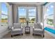 Comfortable sitting area featuring plush arm chairs and bright natural light from the large windows at 508 Moore Hill Way, Holly Springs, NC 27540