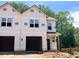 New construction two-story townhome with two-car garage and covered front porch in a wooded, suburban neighborhood at 57 Calluna Dr, Clayton, NC 27520