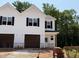 New two-story home featuring white siding, black shutters, an attached garage, and traditional architectural detailing at 57 Calluna Dr, Clayton, NC 27520