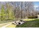 Backyard with stone patio, outdoor seating, fire pit, chain link fence, and trees at 7708 Foxwood Dr, Raleigh, NC 27615