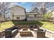 Backyard featuring stone patio with seating surrounding a brick fire pit and a deck at 7708 Foxwood Dr, Raleigh, NC 27615
