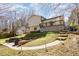Backyard with deck, stone patio with fire pit, and paver pathway with lighting at 7708 Foxwood Dr, Raleigh, NC 27615