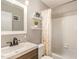 Updated bathroom featuring a modern vanity with a white sink and tile surround tub at 7708 Foxwood Dr, Raleigh, NC 27615